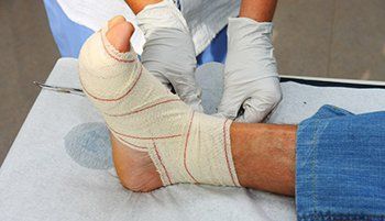 Clinician carefully bandaging a patient’s foot