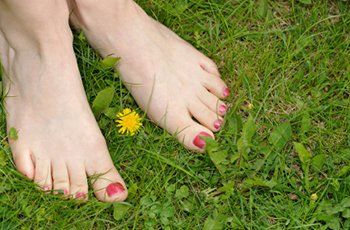Relaxed bare feet resting on green grass